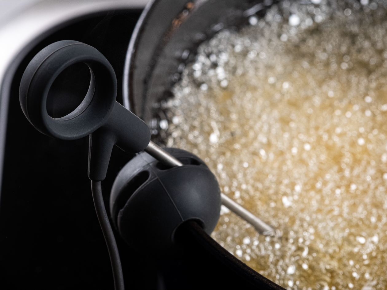 A probe is dipped in a bubbling pot of oil.