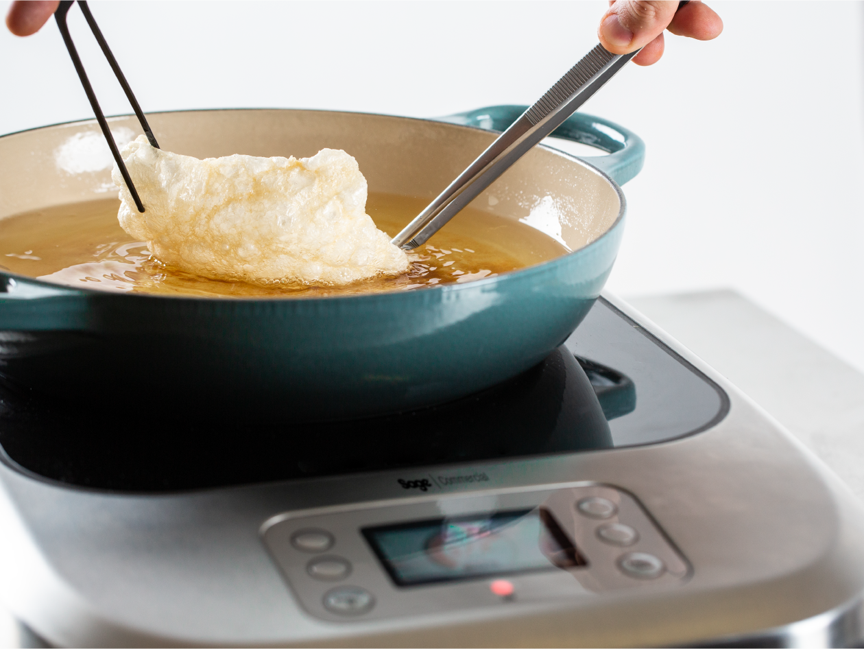 Food is being fried in a pan of oil on top of the precision cooker.