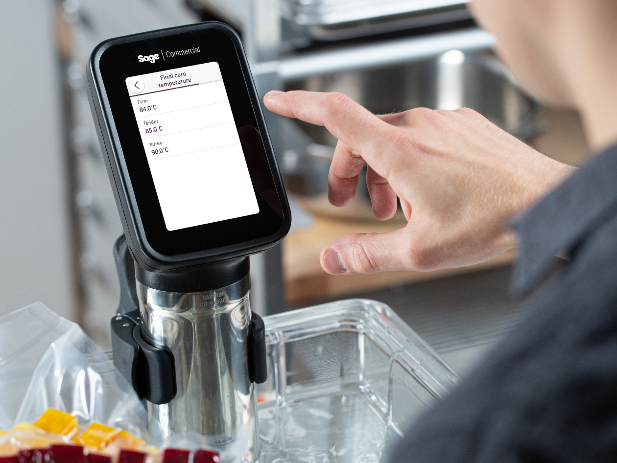 A person touches the screen of the HydroPro™ which is immersed in a container of water.